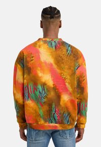 Multicolored sweatshirt met een gedurfd abstract ontwerp in warme oranje, roze en groene tinten. Zachte textuur met ribgebreide manchetten en zoom.