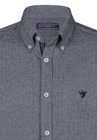 Grijs herringbone-patroon shirt met een button-down kraag, twee knoppen op de kraag en een klein zwart vogellogo aan de linkerkant.