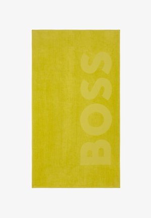Serviette rectangulaire jaune avec le mot « BOSS » embossé verticalement sur le côté droit.