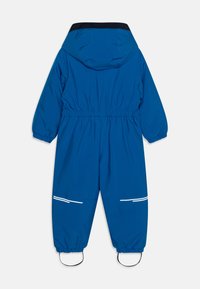 Salopette bleue imperméable avec capuche, taille élastique, poignets élastiques et bandes réfléchissantes blanches sur les jambes. Texture lisse, design décontracté.
