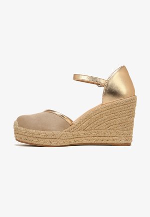 Wedge sandals with a beige fabric toe, gold metallic accents, and a woven jute platform. Features an adjustable ankle strap.