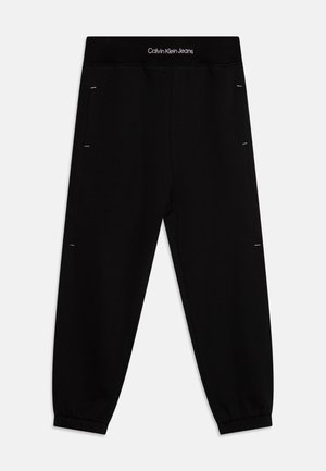 Sorte Calvin Klein Jeans joggebukser med elastiske manchetter og linning, med hvid logotekst på linningen.