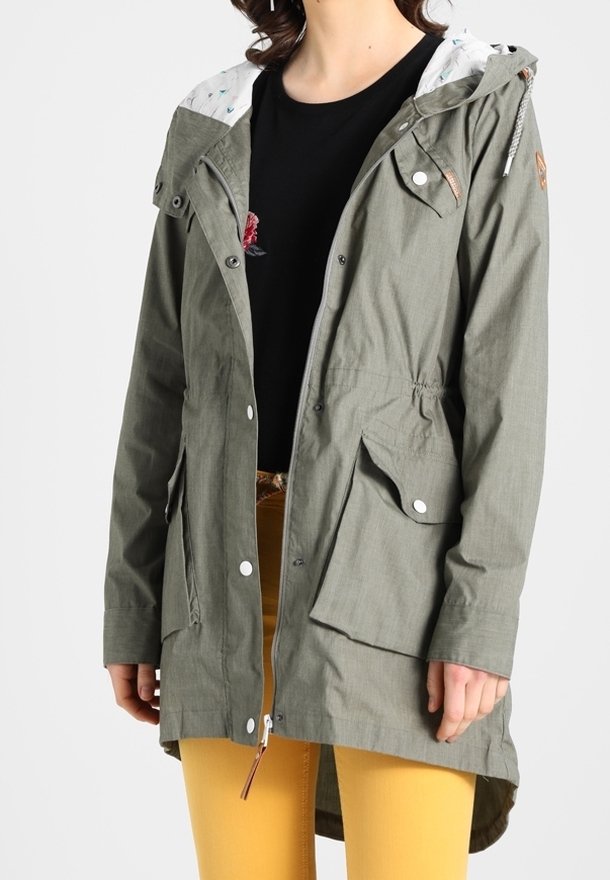 Oliwkowa kurtka z kapturem, z przednimi kieszeniami i zatrzaskami. Posiada wzorzystą podszewkę i ściągnięty w pasie krój. Długi, prosty fason.