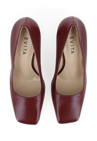 Chaussures à talons hauts en cuir bordeaux avec un bout carré et des découpes. Texture lisse avec une finition mate. "EVITA" imprimé sur la semelle intérieure.