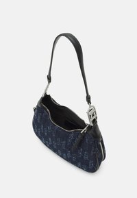 Blå denimaxelväska med svarta läderdetaljer och en silverdragkedja. Har en böjd form och logotypdetalj på hårdvaran.