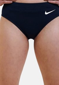 Costumi da bagno blu navy con vita alta e elastico in vita; presenta un piccolo logo Nike bianco sul lato sinistro.