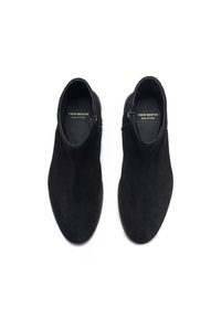 Bottes de cheville en daim noir avec une texture lisse, dotées d'une fermeture éclair sur le côté et d'un design minimaliste, présentées de vue de dessus.