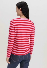Rood en roze gestreept shirt met lange mouwen, ronde hals, gladde textuur en een getailleerd ontwerp. Opvallende stiksels aan de zoom en mouwen.