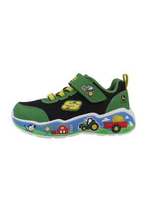 Groene en zwarte kindersneaker met gele veters en boerderijthema-illustraties op de zool, waaronder een tractor, schuur, koe en zon.