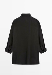 Schwarzes langärmliges Hemd mit hohem Kragen und gefalteten Ärmelsäumen, von hinten vor weißem Hintergrund gezeigt.