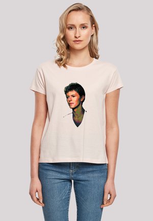 Helles rosa Baumwoll-T-Shirt mit tailliertem Schnitt und kurzen Ärmeln. Mit einem Grafikdruck eines Gesichts in kräftigen Farben und Umrissen.