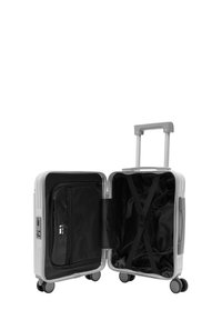 Srebrna twarda walizka kabinowa z wysuwanym uchwytem, czterema kółkami, czarnym wnętrzem, siateczkową kieszenią i elastycznymi paskami krzyżowymi do organizacji.