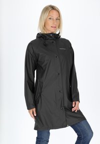 Black waterproof raincoat with a hood, snap buttons, and side pockets. Smooth, glossy texture. Casual knee-length design.