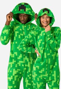 Green fleece onesies with pixelated texture and black creeper face on hoods, featuring full zippers and long sleeves.