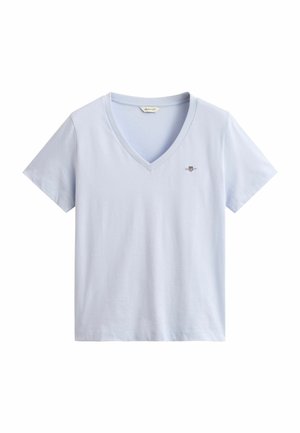 Maglietta azzurro chiaro a maniche corte con scollo a V, logo a scudo piccolo e scritta "GANT" sul petto a sinistra.