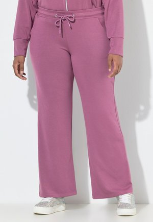 Paarse wijde sweatpants met een elastische tailleband en trekkoord. Zachte stofstructuur, gecombineerd met sprankelende witte sneakers.