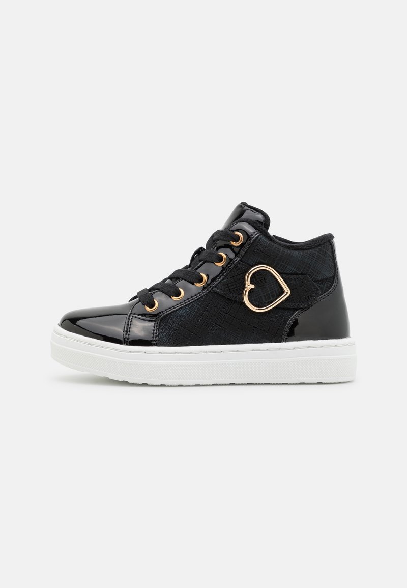 Baskets montantes noires avec semelle blanche, boucle dorée en forme de cœur et lacets noirs sur fond clair uni.