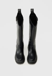 Fekete bőr, térd fölé érő csizmák sima felülettel, kerek orral, vastag talppal és oldalsó cipzárral a könnyű felvétel érdekében. Két húzófül a tetején.