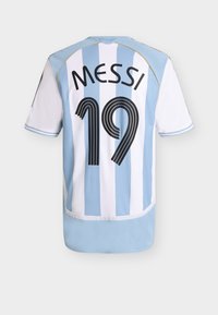 Η εθνική φανέλα ποδοσφαίρου της Αργεντινής με κάθετες γαλάζιες και λευκές ρίγες, που φέρει το όνομα "ΜΕΣΣΙ" και τον αριθμό "19" στην πλάτη.