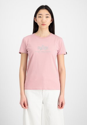 Light pink cotton t-shirt with short sleeves and a round neckline. Features a graphic print logo in silver on the chest.