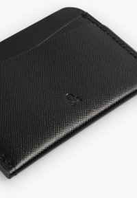 Tarjetero de cuero negro que presenta una superficie texturizada, un diseño delgado y un acento liso en la parte superior. Logo grabado cerca de la parte inferior.