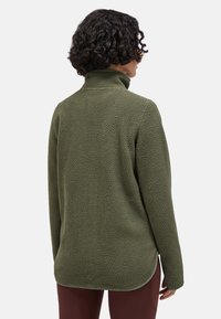 Oliven grøn fleece-pullover med høj krave, struktureret stof og buet kant. Lange ærmer med ribkant. Casual pasform.