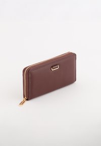 Brun læderpung med en glat tekstur, lynlås lukning og guld hardware accent. Slank, rektangulær design med et minimalistisk udseende.