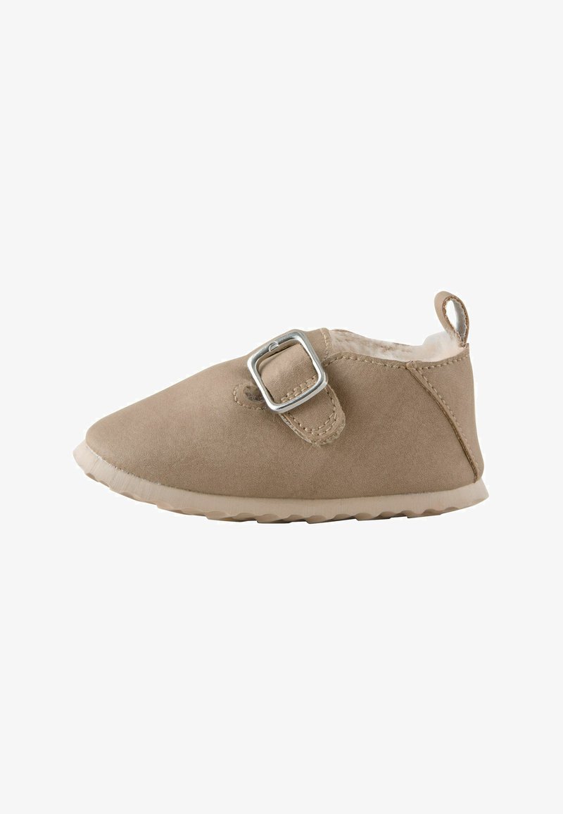 Chaussure beige douce pour tout-petit avec semelle rembourrée, bride ajustable à boucle argentée et languette au talon pour un enfilage facile.