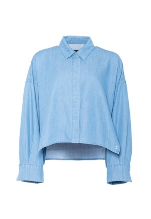 Camisa vaquera azul claro de manga larga y corte cropped, con cuello clásico y tapeta de botones oculta, que presenta puños anchos y un dobladillo ligeramente curvado.