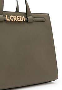 Bolso de mano de piel verde oliva con el logo dorado "L.CREDI". Cuenta con asas resistentes, una forma estructurada y una textura suave.