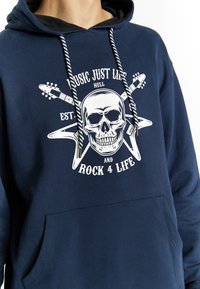 Felpa blu navy con grafica di un teschio accompagnato da chitarre e testo. Dettagli aggiuntivi includono i lacci con un motivo a contrasto e una tasca frontale.