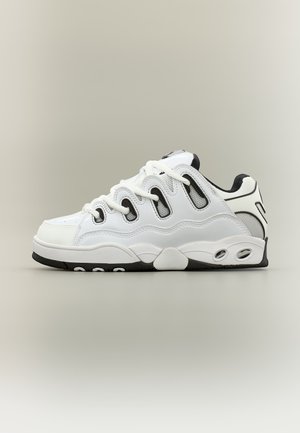 Weißer und schwarzer Sneaker mit niedrigem Schaft, einzigartigen wellenförmigen Ausschnitten, dicker Sohle und weißen Schnürsenkeln vor einem schlichten neutralen Hintergrund.