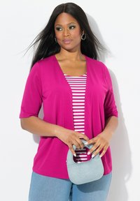 Cárdigan fucsia sobre una blusa a rayas, combinado con un bolso azul claro. Mangas de longitud media, tejido suave y un ajuste relajado.