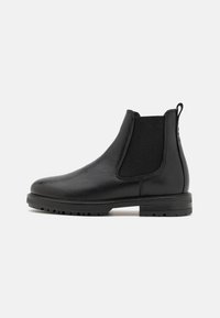 Black leather Chelsea boot with elastic side panels, textured finish, rounded toe, pull tab, and a rugged rubber sole.