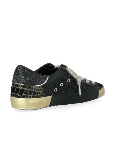 Sneaker nera con accenti glitterati neri, texture squamosa sul tallone, punta metallizzata dorata e lacci argentati. Design low-top.