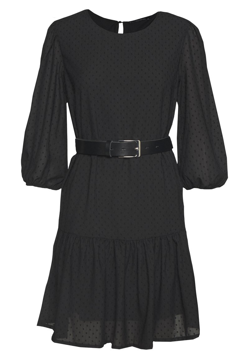 Svart klänning i lätt tyg med puffärmar, figursydd midja, ett bälte och en lager-på-lager volangnederdel. Har ett subtilt prickmönster.