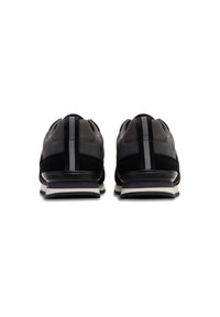Black and gray sports shoes featuring a cushioned sole, textured fabric, and sleek design with vertical accent stripes on the heel.