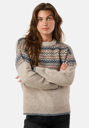 Beige gebreide trui met gemusterde blauwe, roze en zwarte accenten. Heeft ribgebreide manchetten en zoom, en een ronde halslijn. Comfortabele textuur.