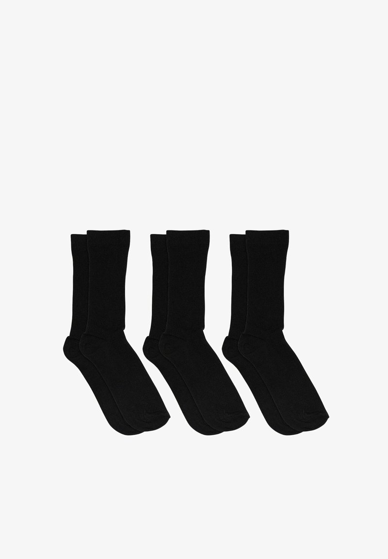 Trois paires de chaussettes noires unies, longueur mi-mollet, disposées côte à côte sur un fond blanc.