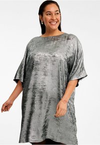 Silbermetallisches, übergroßes Kleid mit Rundhalsausschnitt, kurzen Ärmeln und einer glatten, leicht strukturierten Oberfläche.