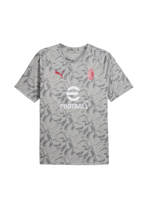 Lys grå t-shirt med camouflage mønster, Puma-logo i rød og en hvid "FOOTBALL" grafik. Korte ærmer og rund halsudskæring.