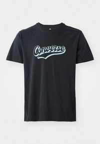 Črna bombažna majica s turkiznim logotipom "Converse", okroglo izrezana in s kratkimi rokavi, z gladko teksturo.