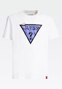 Camiseta blanca de algodón con un gráfico triangular púrpura que presenta diseños de dibujos animados divertidos, texto "GUESS U.S.A." y un acento de logo rojo en el dobladillo.