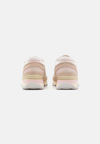 Sneakers con una toma superiore in rete rosa chiaro, dettagli in suede e un tallone bianco. Presentano una suola ammortizzata con un battistrada in gomma testurizzata.