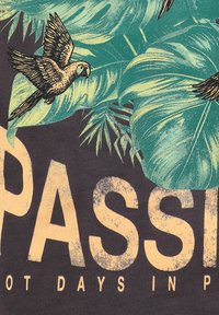 Fliegende Papageien und große tropische Blätter über dem abgenutzten Wort „PASSI“ auf dunklem Stoff.