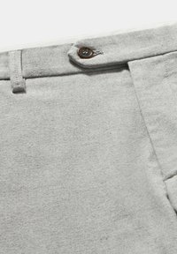 Grijze katoenen broek met een gladde textuur, voorzien van een bruine knoopsluiting en bijpassende stiksels op de tailleband en zakken.