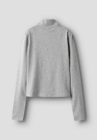 Haut gris à manches longues avec un col montant, en tissu doux et extensible. Il présente un design cropped et une texture unie, sans motifs visibles.