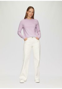 Lichtpaars lange mouwen trui met een ronde halslijn, gecombineerd met hoge taille witte wijdvallende jeans en witte sneakers.