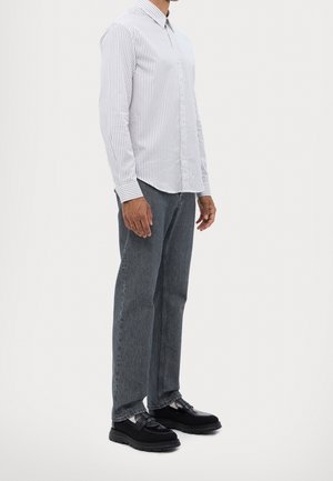 Gestreepte blouse in wit en blauw, gecombineerd met grijze denim jeans en zwarte platte schoenen, met een klassieke kraag en lange mouwen.