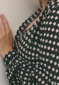 Patroonkleed met een groen-wit ruitjesdesign, gemaakt van zachte stof, met lange mouwen en een aansluitende silhoeet.